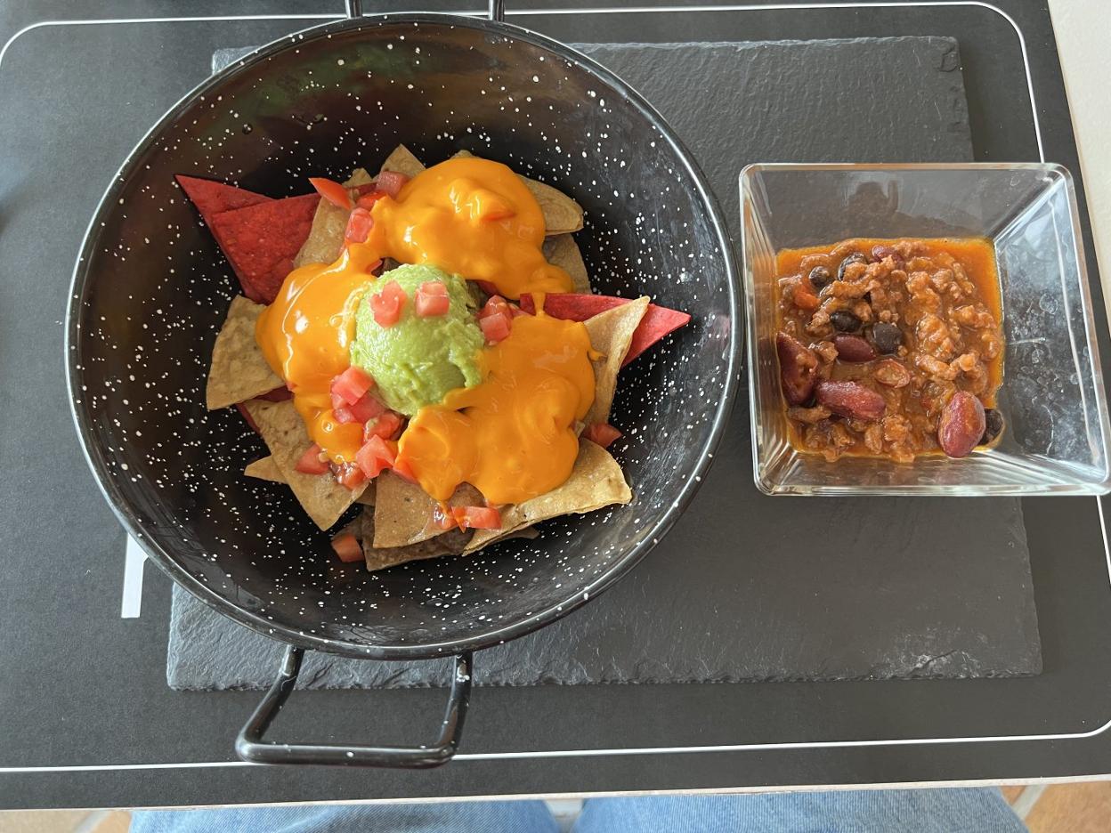 Nachos clásicos, con queso, guacamole y jalapeño, y chili con carne. 