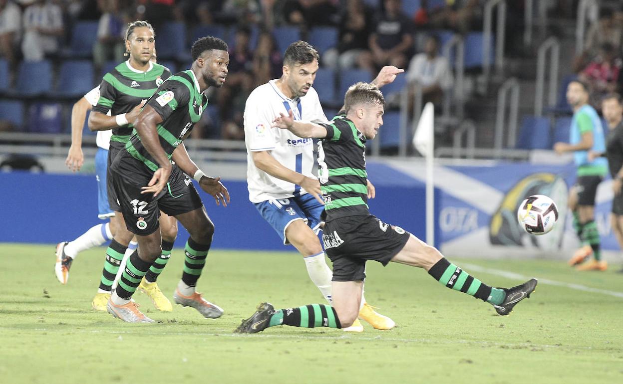 Dani Fernández trata de llegar a un balón ante la mirada de Sekou Gassama y Mboula, ayer durante el partido ante el Tenerife en el Heliodoro. 