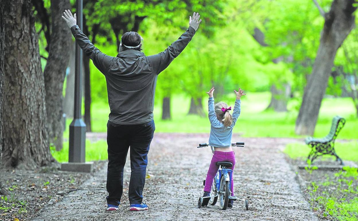 Un padre juega con su hija en un parque