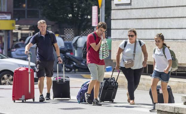 Turistas con maletas por la plaza de Alfonso XIII el pasado mes de agosto.