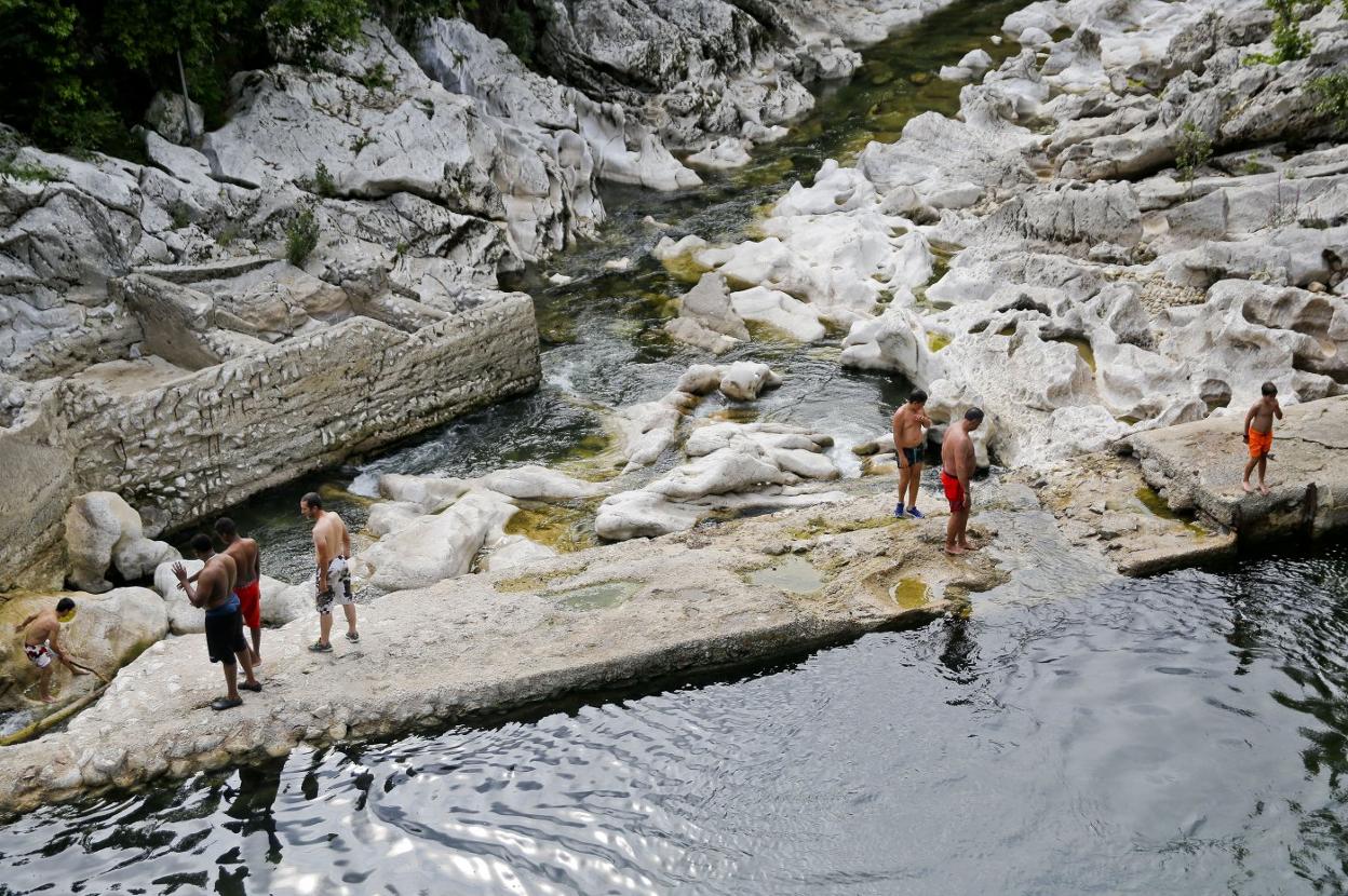 Varios bañistas en el río Pas, a la altura de Puente Viesgo.