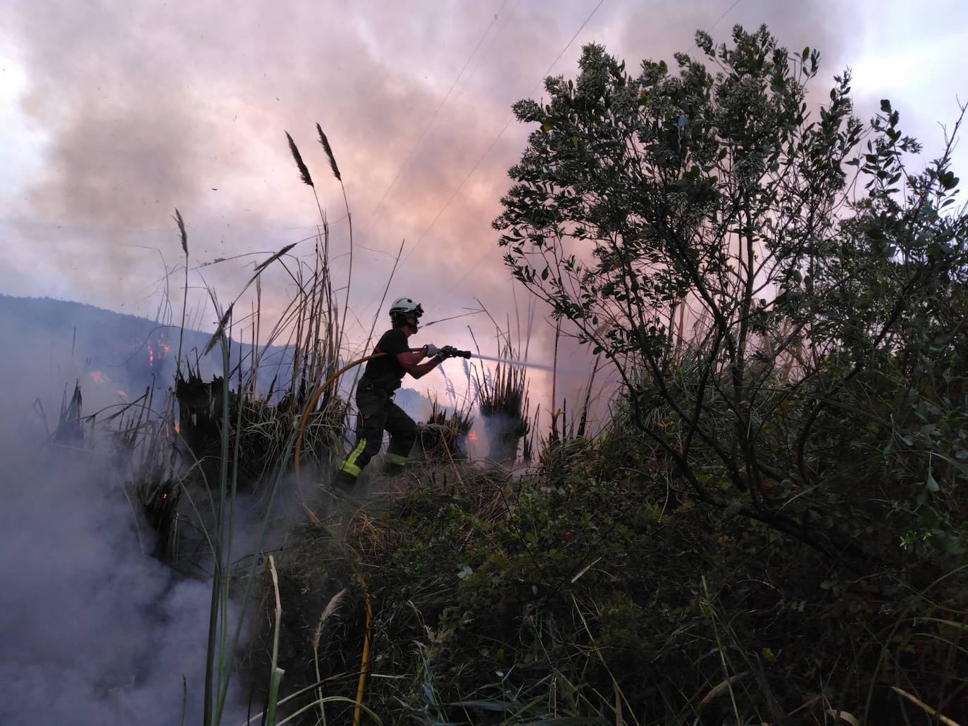 Imagen principal - Imágenes del operativo de extinción del incendio en Voto.