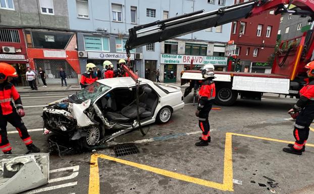 Los bomberos trabajan para retirar el vehículo siniestrado tras excarcelar al conductor.