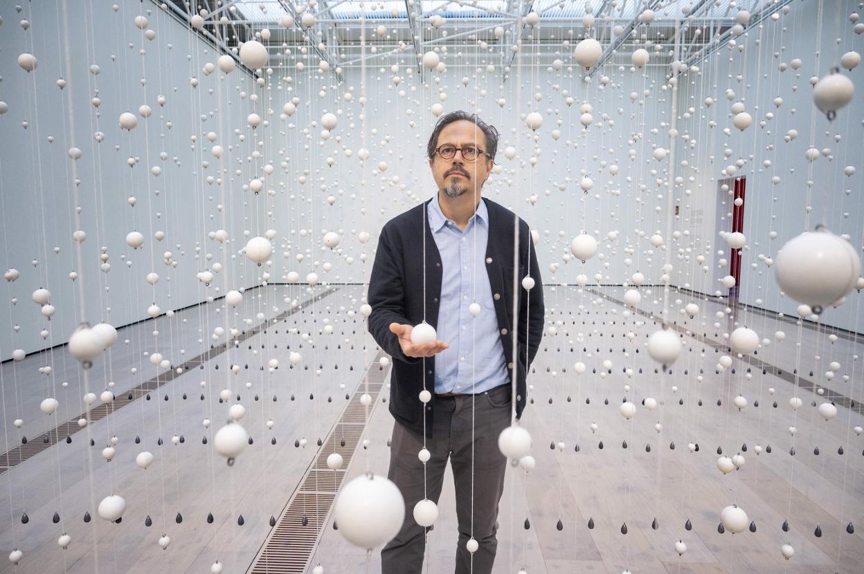 Damián Ortega sumergido literalmente en su obra 'Warp Cloud' (2018), representando la estructura química de una gota de agua a través de esferas blancas.