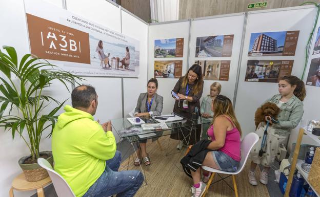 Imagen. Un matrimonio se informa en el estand de A3B Gestión Inmobiliaria. 