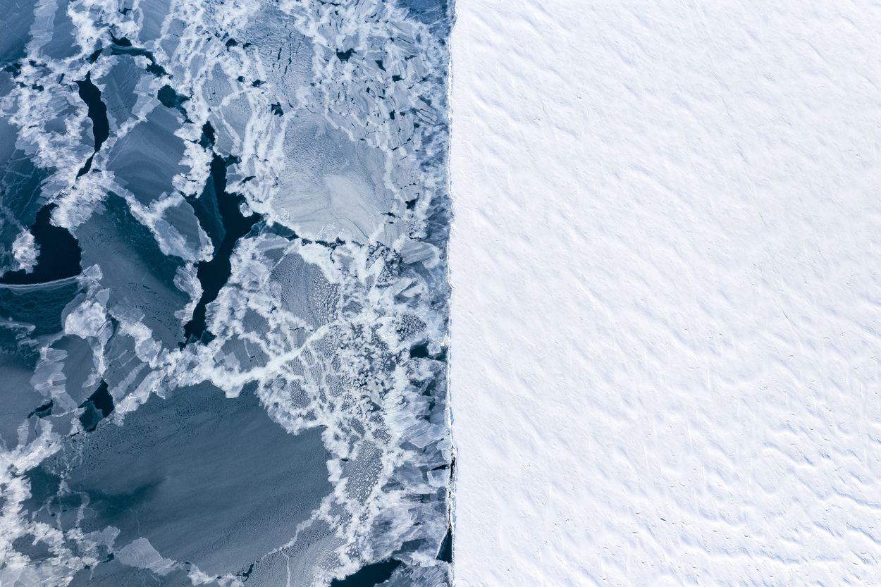 Vista aérea de dos tipos diferentes de hielo en invierno. En el lado derecho, el hielo fijo bien establecido. A la izquierda, el agua abierta recongelándose después de que una tormenta se llevara el hielo. 