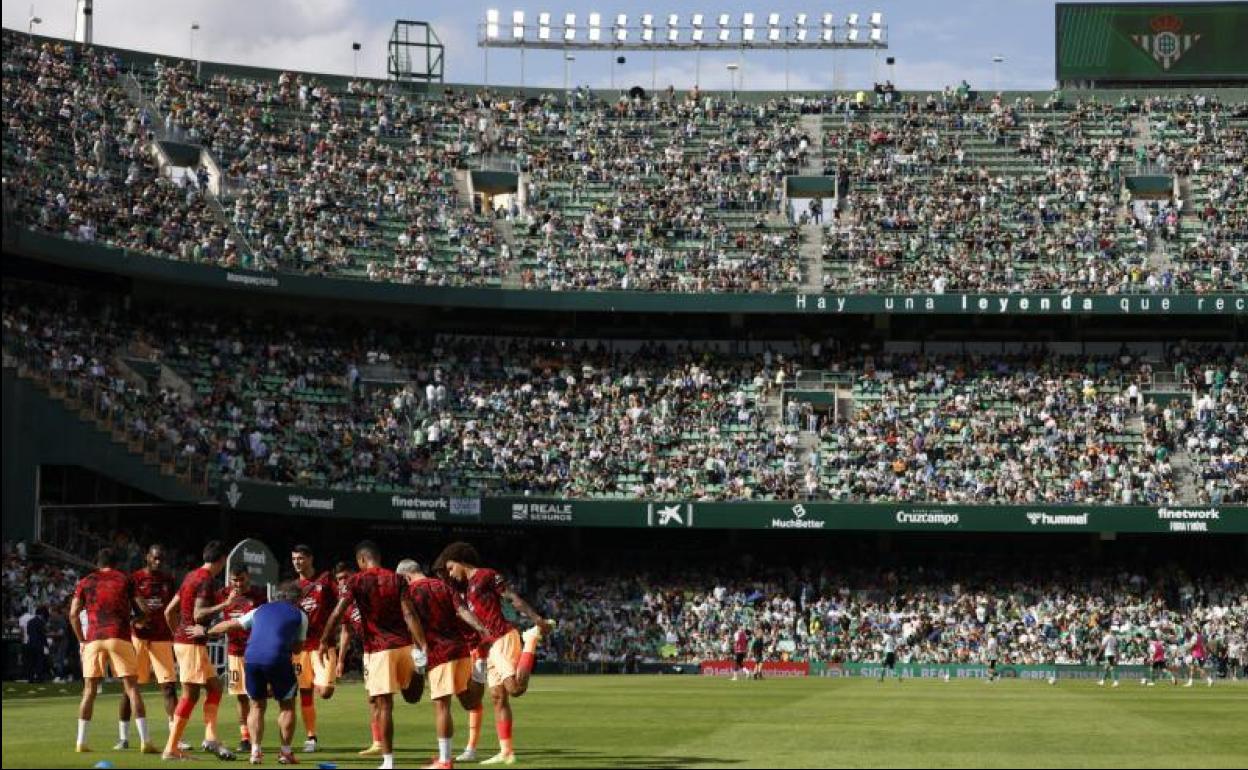 Los jugadores del Atlético calientan en el Benito Villamarín. 