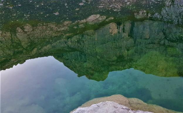 El reflejo de los Paredones de Albo en las aguas de las Moñetas le da al lugar un aspecto de cumbre invertida y cielo en los pies 