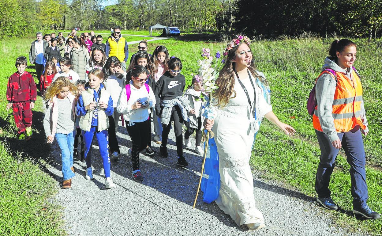 La anjana Aia acompaña a niños y mayores, ayer, en su paseo por La Viesca. 