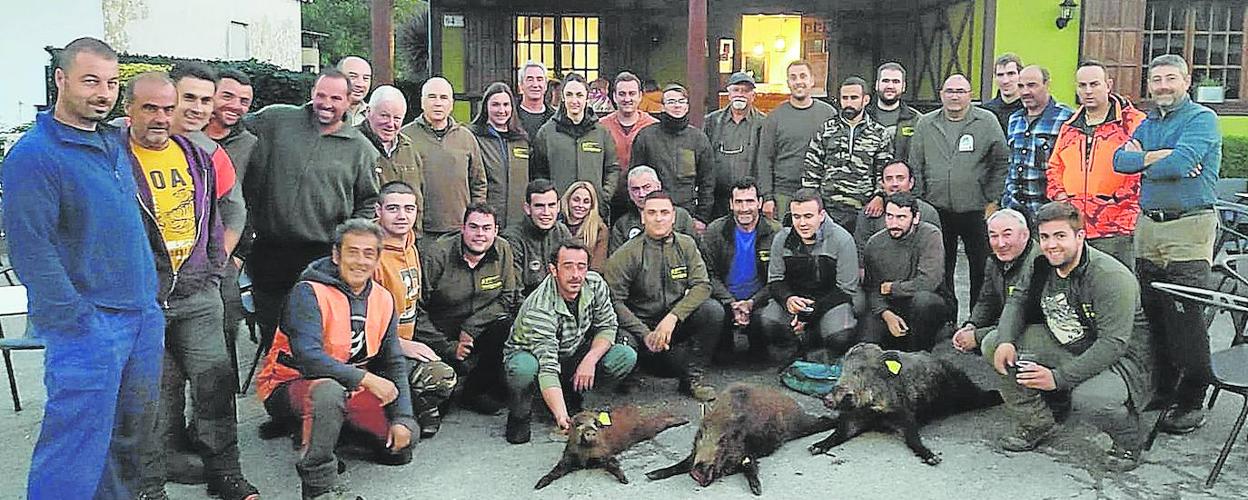 Integrantes de la cuadrilla 145, de Roberto Fernández, de Silió, con los tres jabalíes cazados este domingo en Coo. 