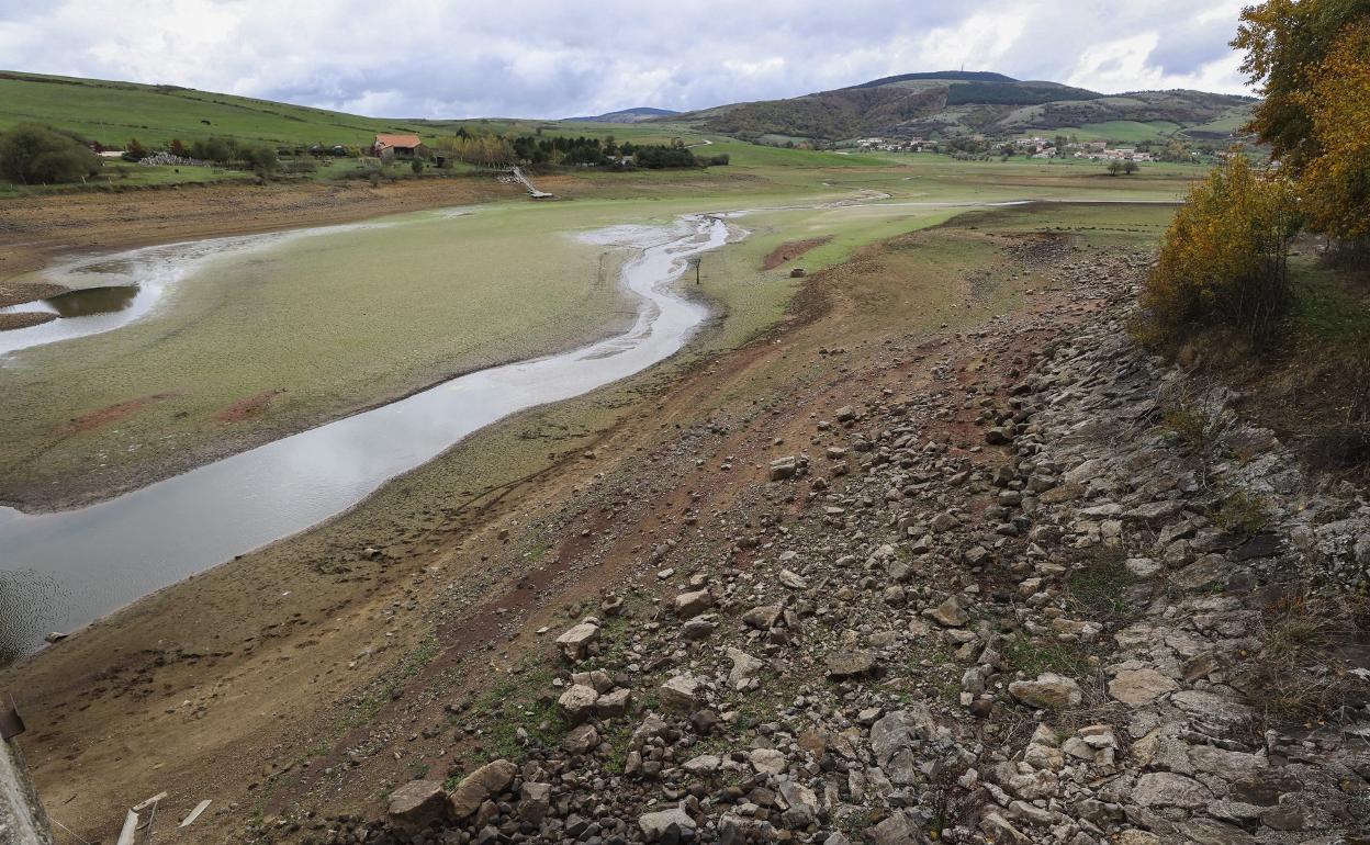 Zona rocosa, fango reseco y dos pequeños 'riachuelos' en una zona casi vacía de agua. 