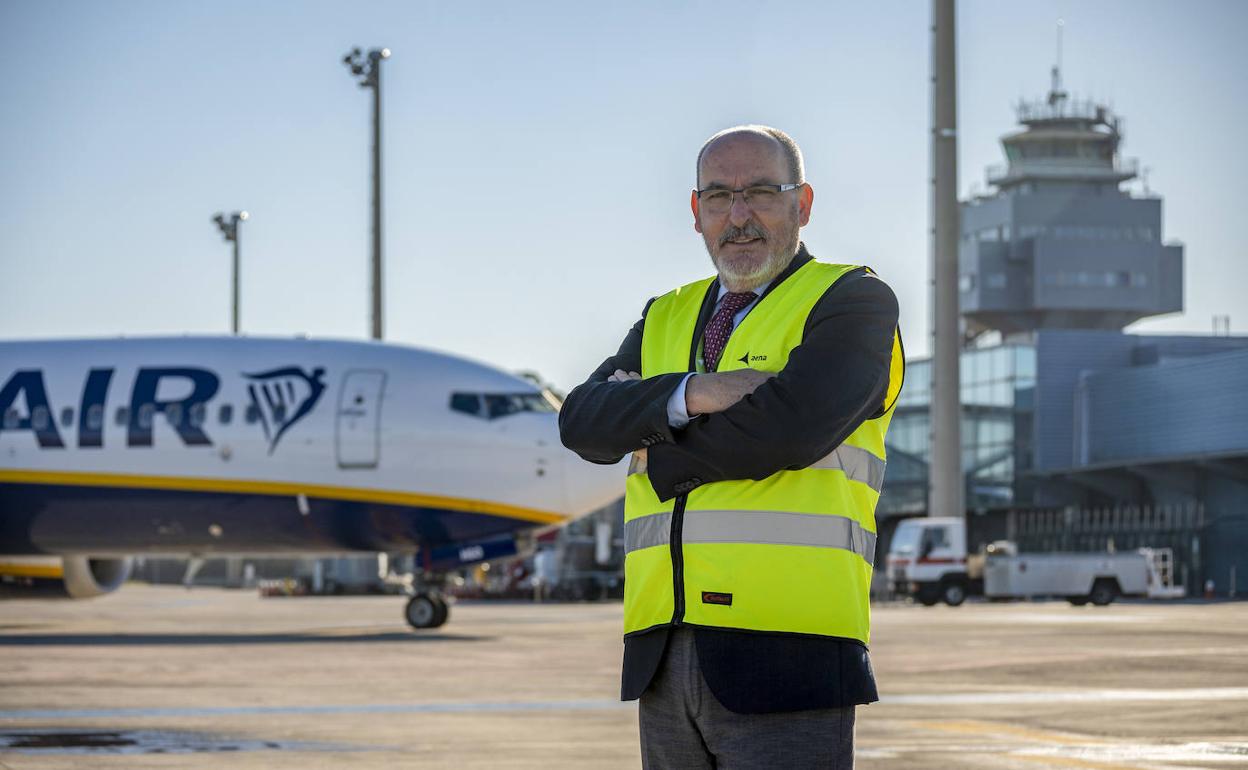 Bienvenido Rico, en la pista del aeropuerto, con un avión a punto de despegar y la torre de control de fondo. 