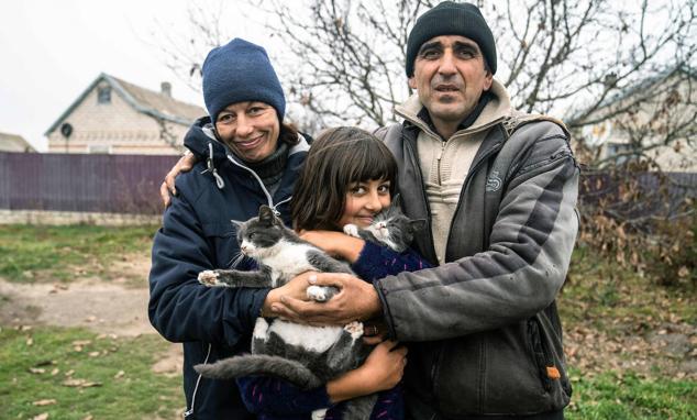 Viktor Galak (derecha), de 44 años, posa con su esposa Svitlana (izquierda), de 43 años, y su hija Anna (centro), de 10 años, en el pueblo liberado de Pravdyne, en la región de Jersón, el 12 de noviembre de 2022. La población local reaccionó con júbilo a la liberación de Jersón tras ocho meses de ocupación rusa.