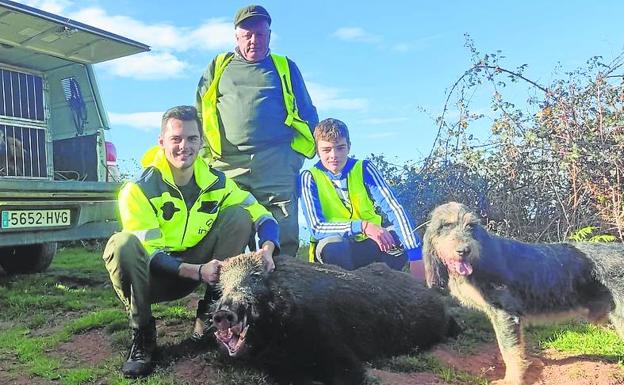 Pedro Fernández, jefe de la cuadrilla 90, junto a sus hijos, con un jabalí abatido en el lote de El Táladro en esta temporada. 