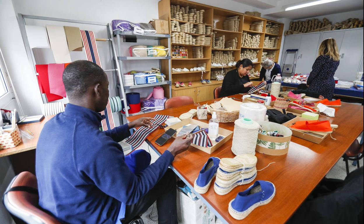 Cursos. Algunos usuarios de la Cocina Económica, ayer por la mañana, cosen alpargatas que luego se venden en el comercio solidario.