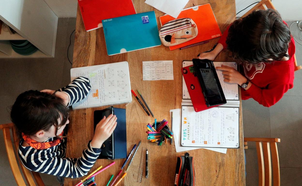 Dos escolares realizan sus tareas educativas en casa en una imagen captada en 2020. 