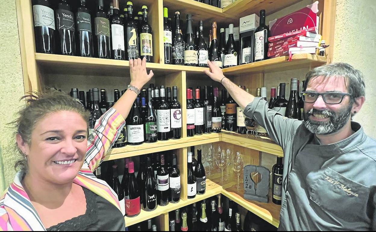 Noelia y Quique indican la estantería que dedican exclusivamente, en la cava del restaurant,e a los vinos de Cantabria. 