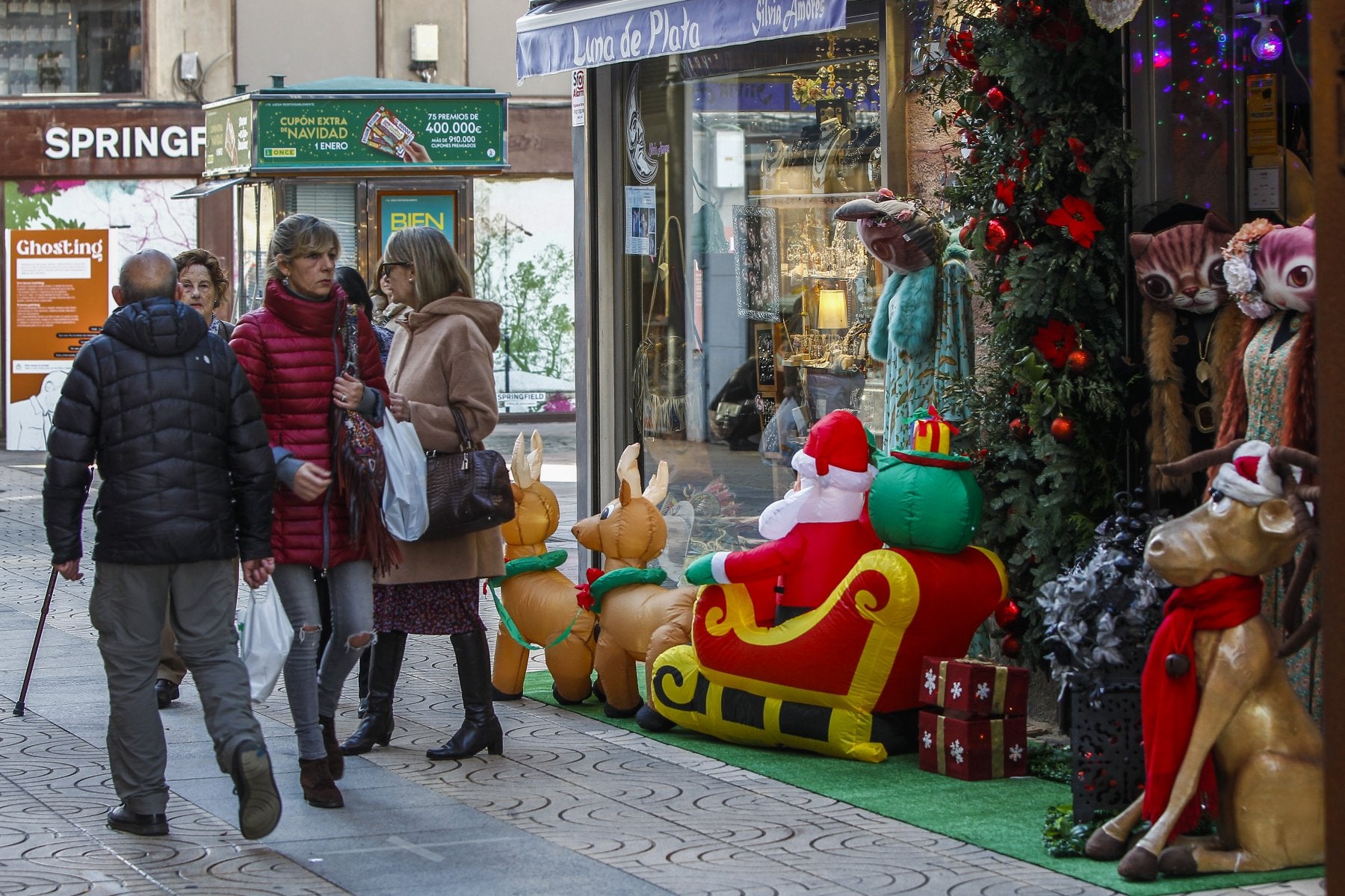 Clientes caminan por la calle Consolación, una de las arterias comerciales engalanadas para las fiestas, ayer, en Torrelavega. 