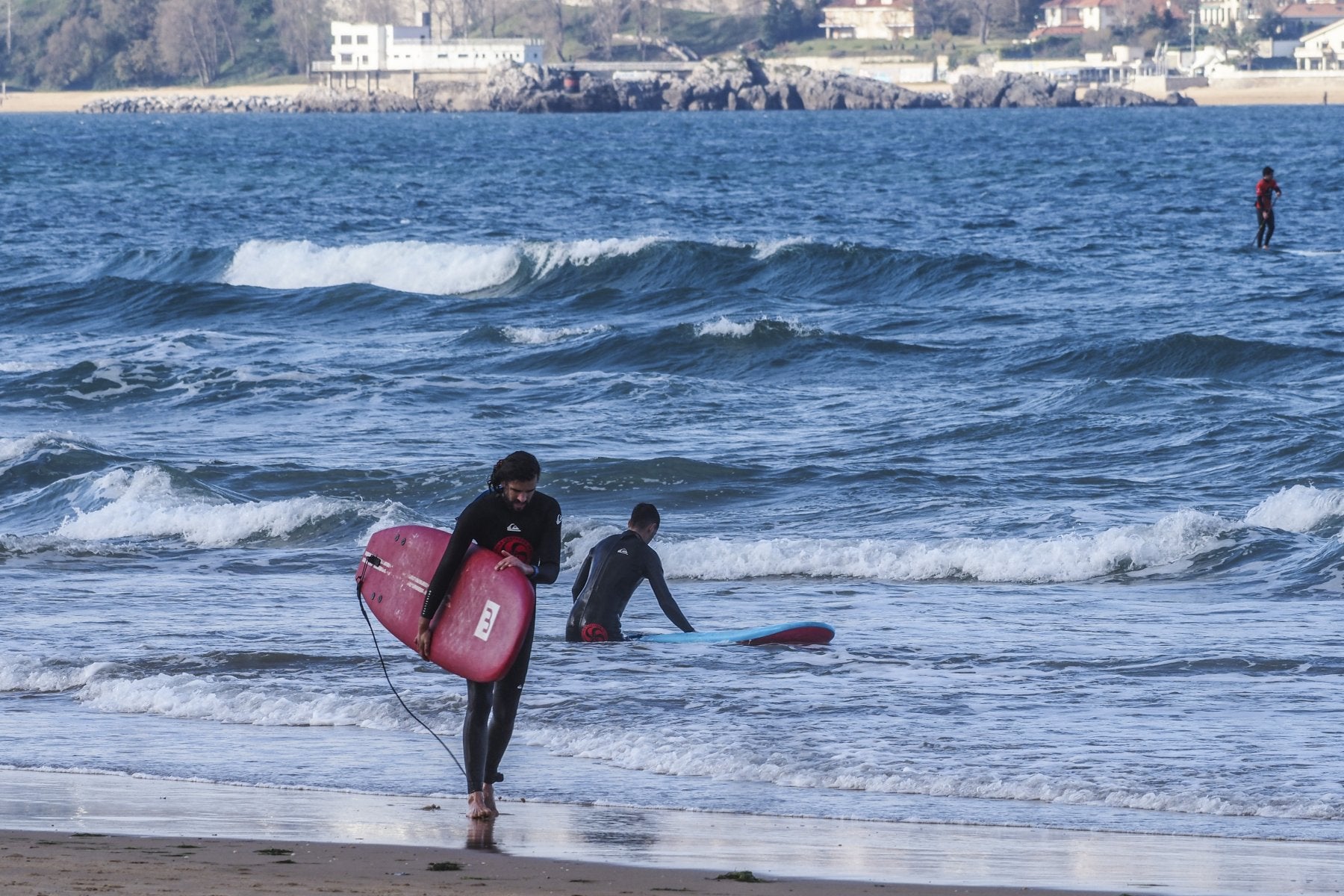 Varios surfistas cogen olas en la playa de Loredo, en el municipio de Ribamontán al Mar. 