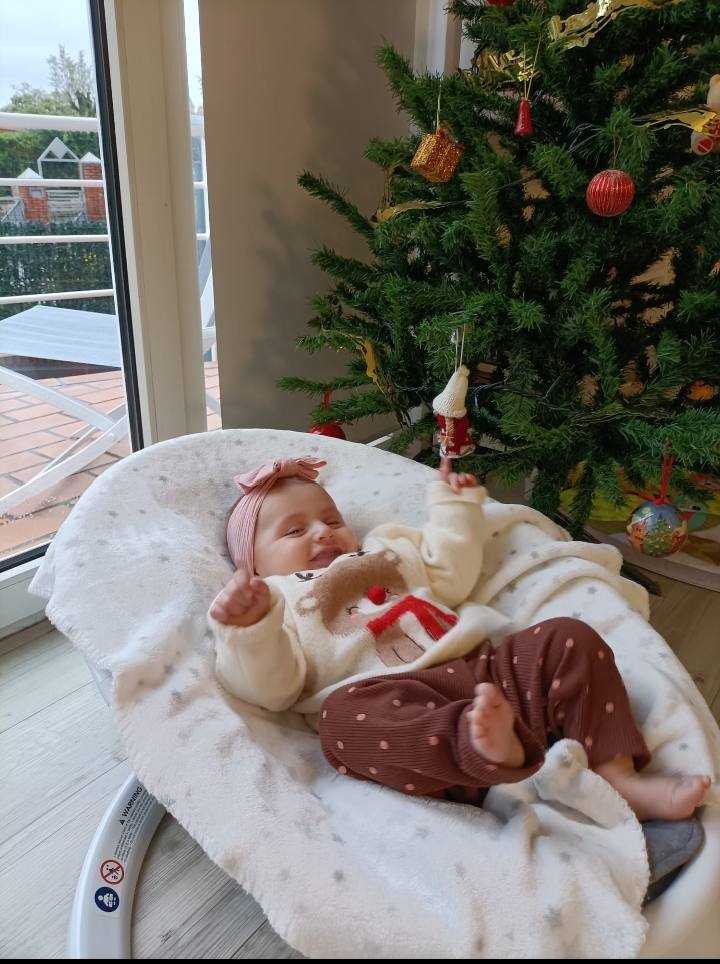 África Luna Cobo vive sus primeras navidades y con solo tres meses ya le encantan las luces de Navidad. En la foto, muy contenta al lado del árbol que sus padres han instalado en su casa, en Muriedas.