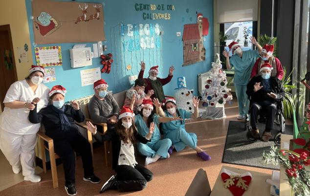 Usuarios y trabajadores del Centro de Dia de Colindres celebran juntos estas fiestas de Navidad. Esta fotografía, con parte de la decoración navideña que han realizado ellos, sirve para desear unas felices fiestas a todos.