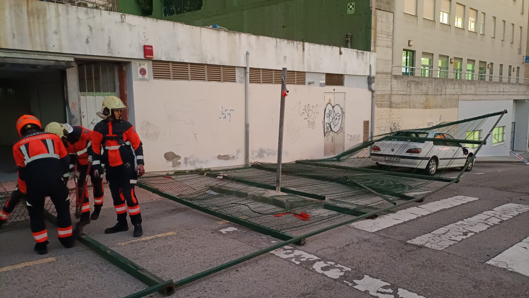 Los bomberos de Santander desmontan la valla del colegio San Martín.