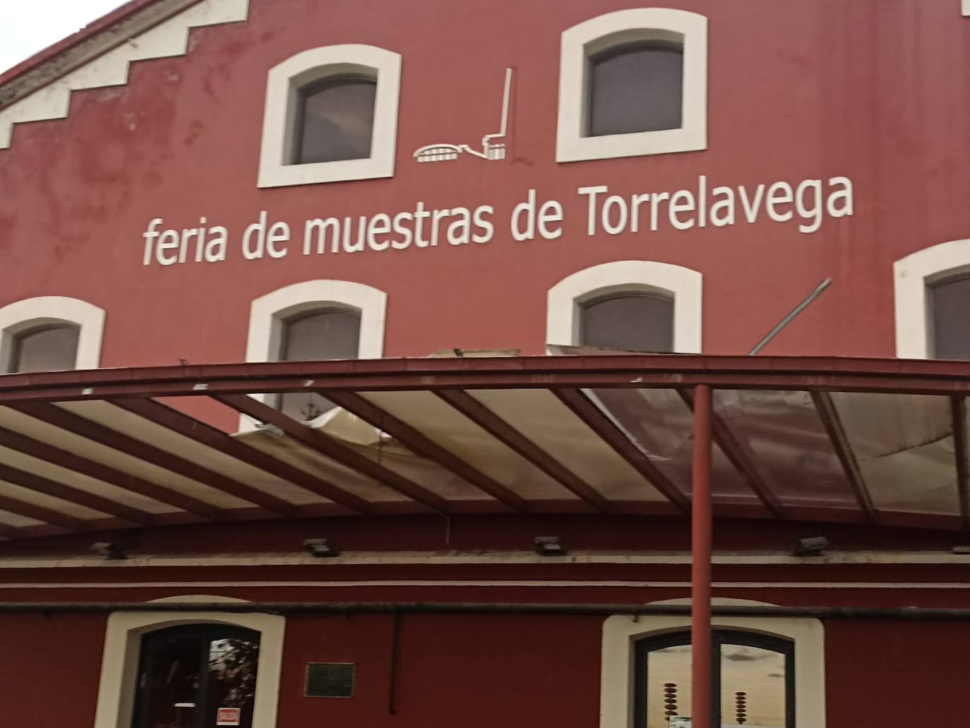 El fuerte viento ha levantado y destrozado parte de la cubierta de la entrada principal del recinto de La Lechera, en Torrelavega.