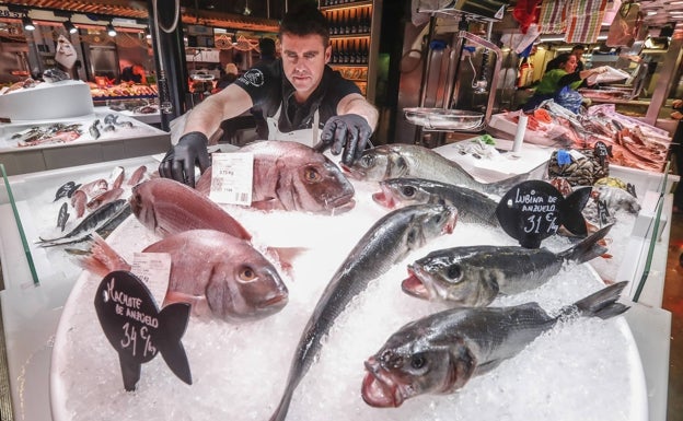 Luis Castanedo, pescadero, coloca los machotes y las lubinas de su puesto ubicado en el Mercado de la Esperanza.