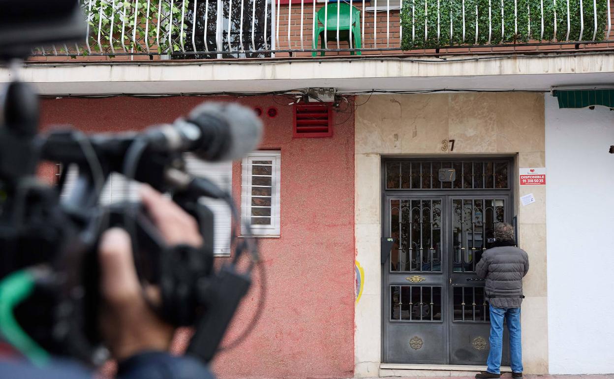 Un hombre mira el portal en el que se ha producido el crimen de Vallecas.