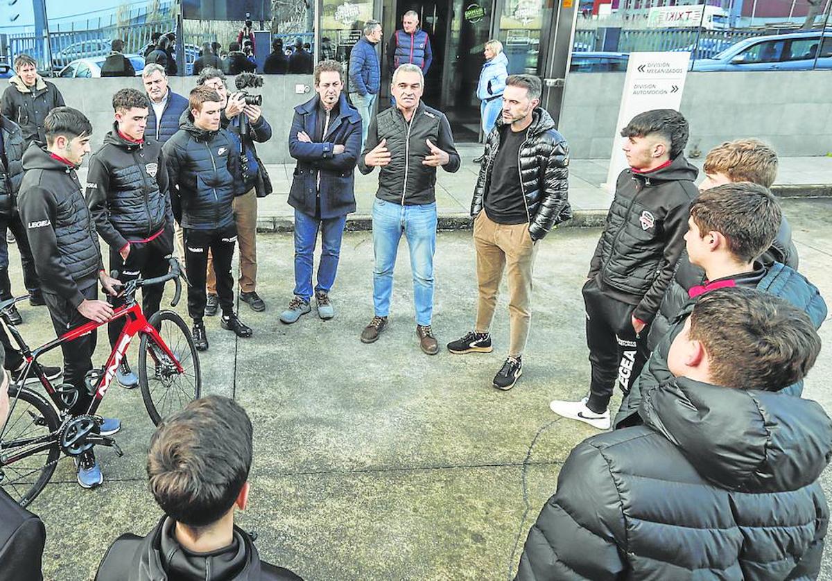 Igor González de Galdeano, con Samuel Sánchez a su izquierda y Rafael Gómez a su derecha, explica a los jóvenes ciclistas el proyecto en la entrada de la planta de Gomur. javier cotera