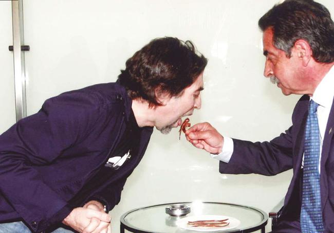 Las anchoas se han convertido en un estandarte institucional desde que el presidente empezó a usar este producto cántabro como regalo en las visitas oficiales y cada vez que se cruzaba con amigos o famosos. En la imagen, Revilla ofrece una anchoa a la boca al cantante y compositor Joaquín Sabina.