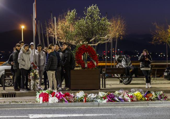 Amigos del joven atropellado en Castelar, el pasado lunes, en el paseo tras depositar una corona de flores y pegar unas fotografías en la señal de velocidad.