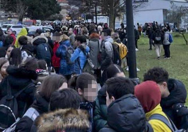 Los alumnos esperan en las inmediaciones del instituto mientras los agentes revisan todos los recovecos del edificio para asegurar que la seguridad está garantizada.