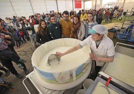 Un grupo de visitantes observa cómo se elabora queso