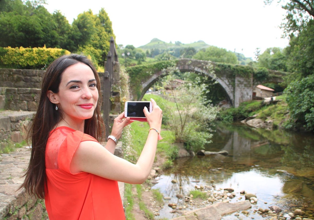 Una turista hace una fotografía del Puente Mayor de Liérganes