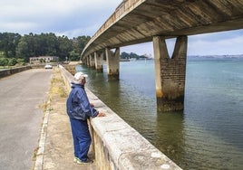 Un hombre observa los evidentes desperfectos que hay en los pilares del puente de Somo