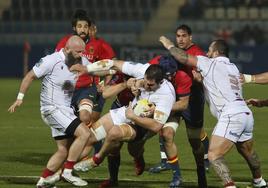 Mikautadze lleva el oval mientras el placado por dos defensores españoles.