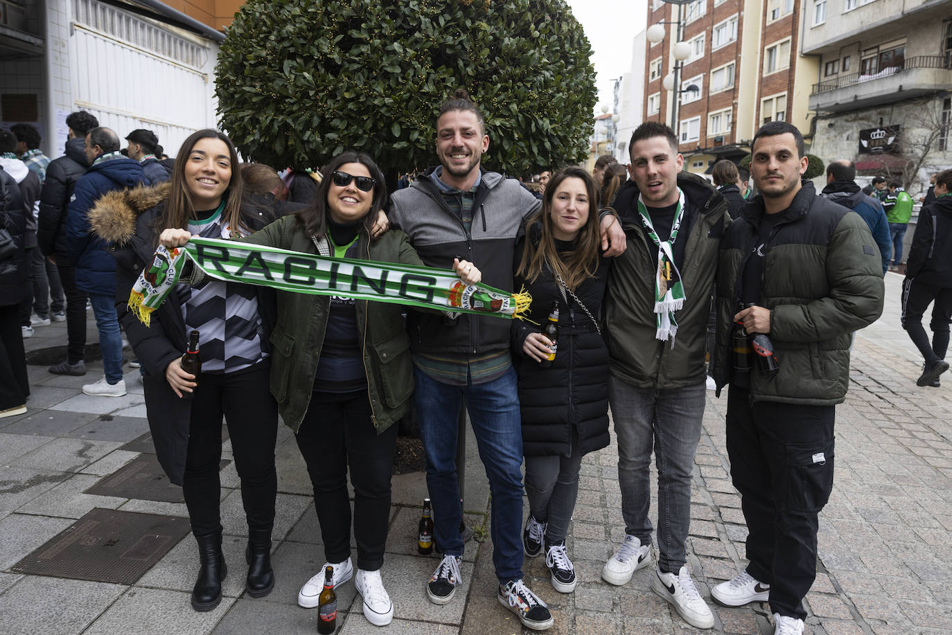 Un grupo de aficionados posa con la bufana del Racing en la calle Tetuán.