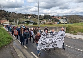 Los vecinos marcharon hoy por la carretera con carteles de protesta.