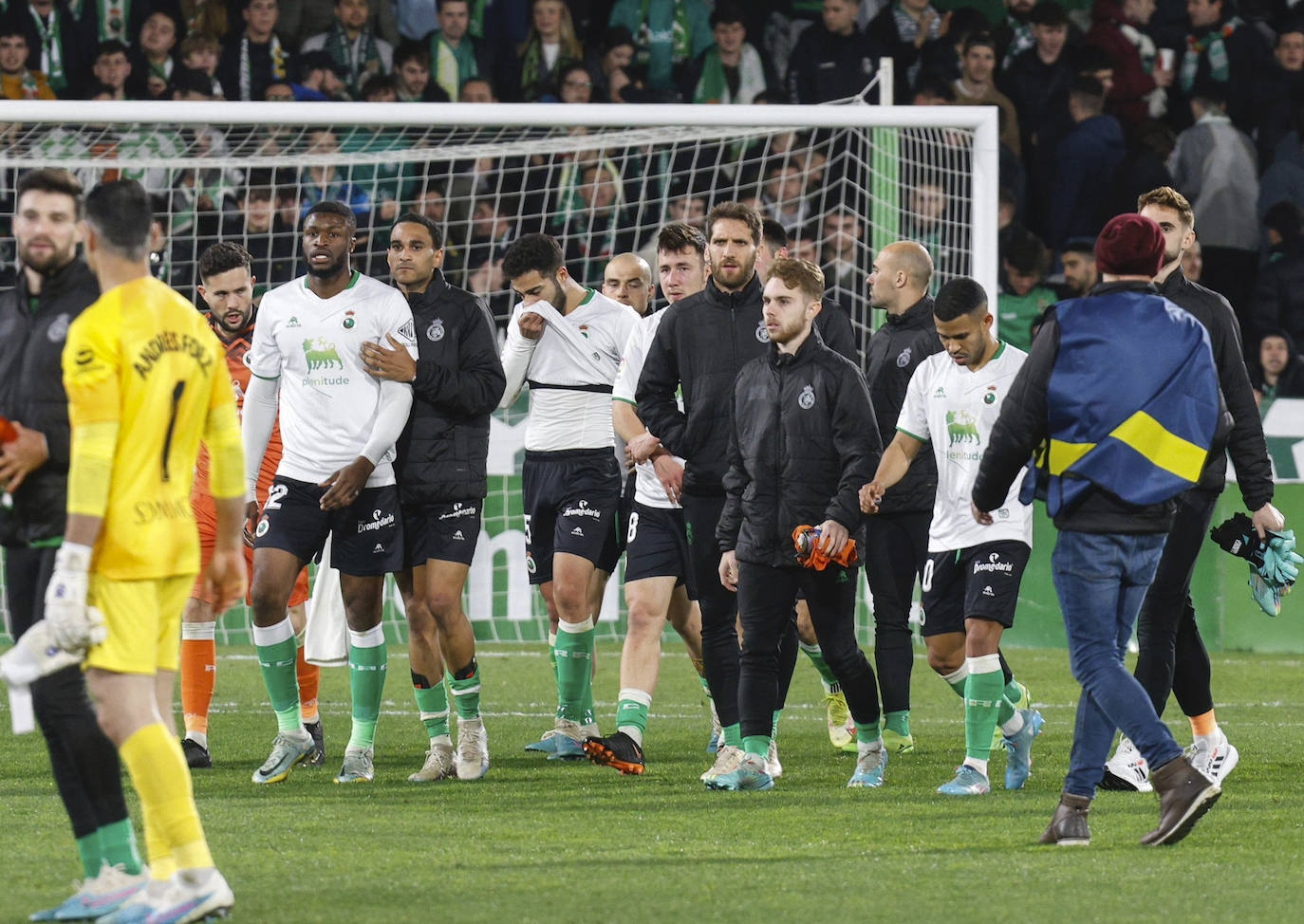 Los futbolistas del Racing abandonan el terreno de juego de los Campos de Sport tras el empate.