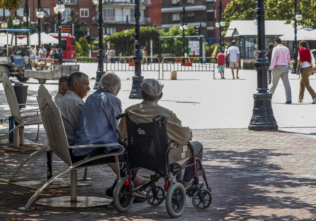 Un grupo de personas mayores conversa en un banco del Bulevar Demetrio Herrero.