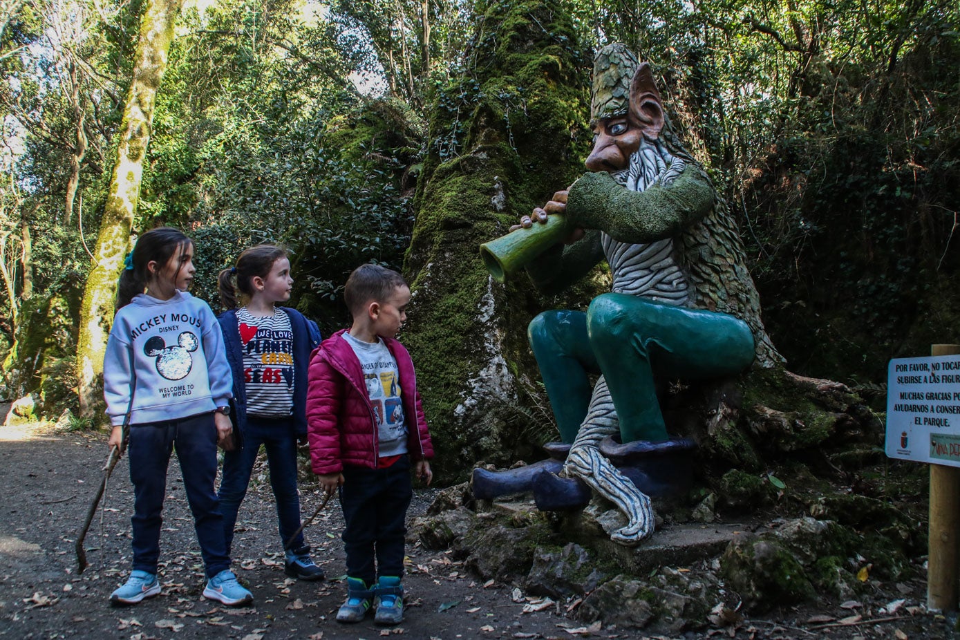 Los niños frente al Musgoso, una de las dos figuras originales del recinto que se ha podido conservar tras los sucesivos destrozos vandálicos.