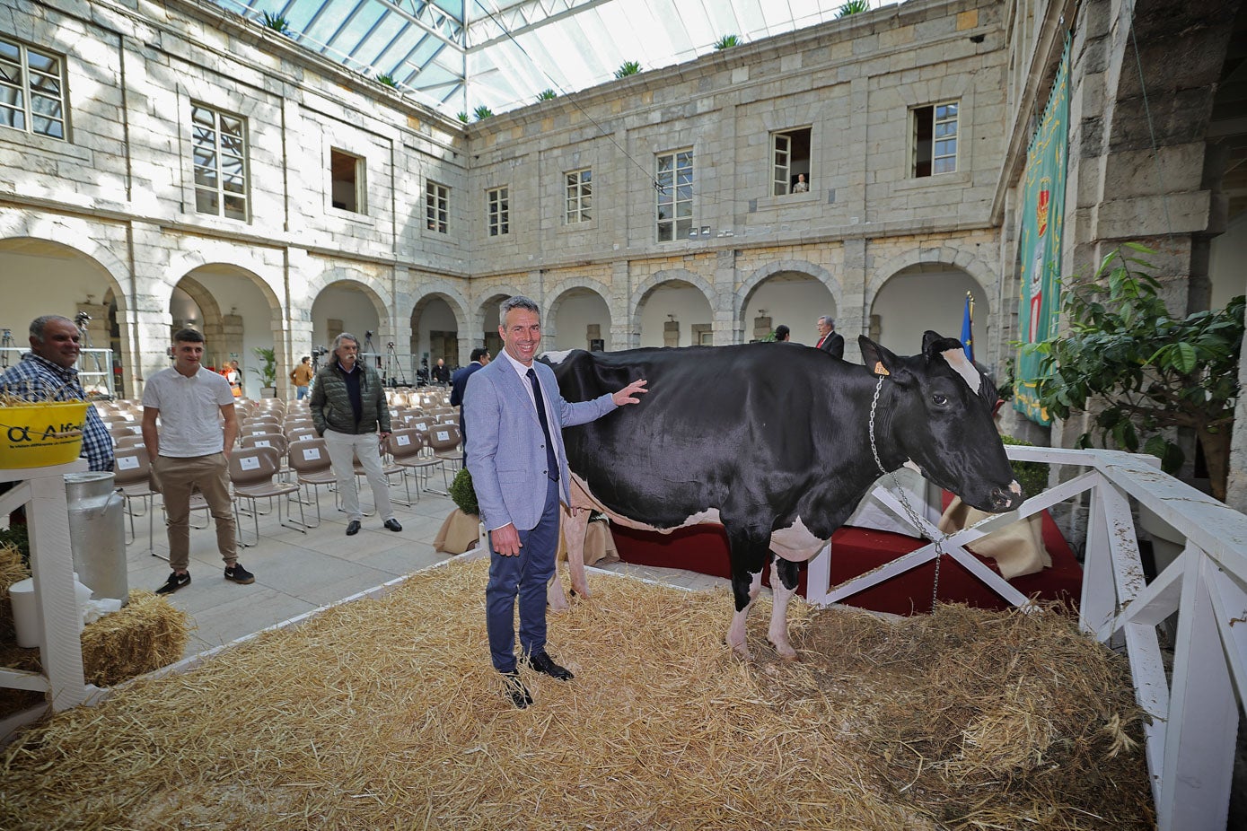 Agapito Fernández, criador de Ariel, posa junto a su vaca en el establo del Parlamento habilitado para el animal