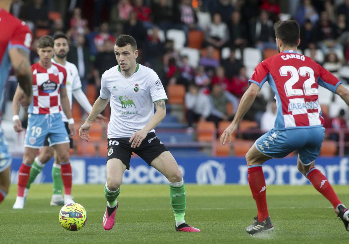 Íñigo Vicente controla el balón ante la oposición de Carbó.