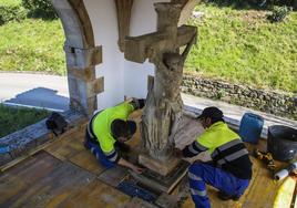 Juanjo Cano y Óscar Camino, los dos obreros responsables de la restauración, en la instalación de la imagen.