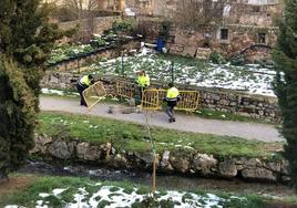 Operarios municipales vallando uno de los soplados que aparecen en los dos márgenes del arroyo Las Fuentes, en Reinosa.