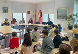 Los niños y niñas de Comillas celebran el V pleno del Consejo de Infancia y la Adolescencia, acompañados de los políticos.