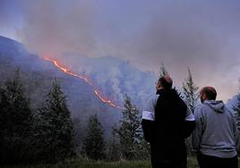 El fuego avanza por la ladera de la Hoz de Santa Lucía bajo la atenta mirada de unos vecinos.