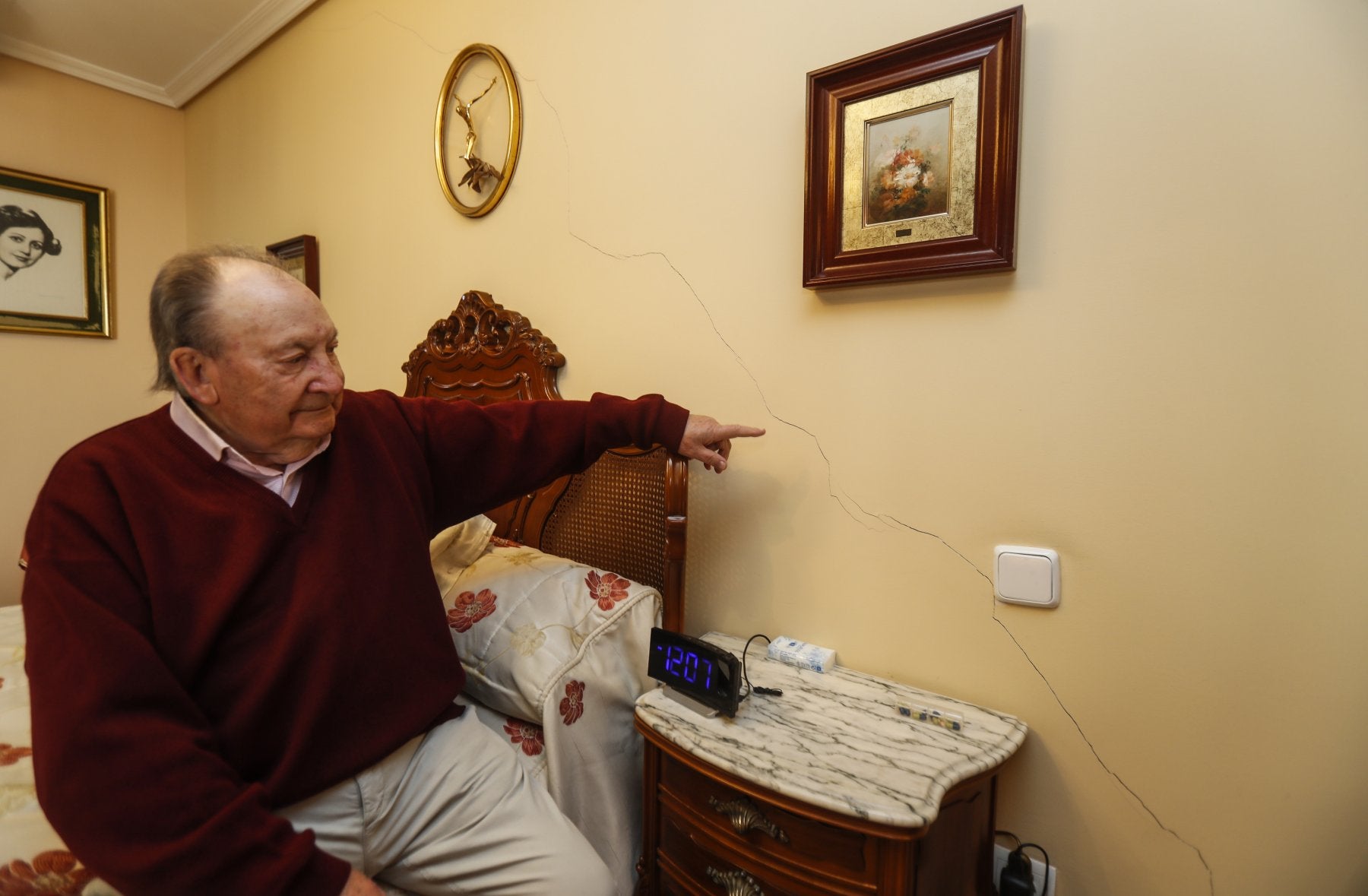 Un vecino de un edificio ubicado justo detrás del banco señala las grietas que han aparecido en su casa.