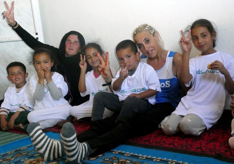 Dulce Roateche y Carmen Cacho, en el interior de una de las estancias en los campamentos, con un grupo de niños con camisetas de Piélagos.